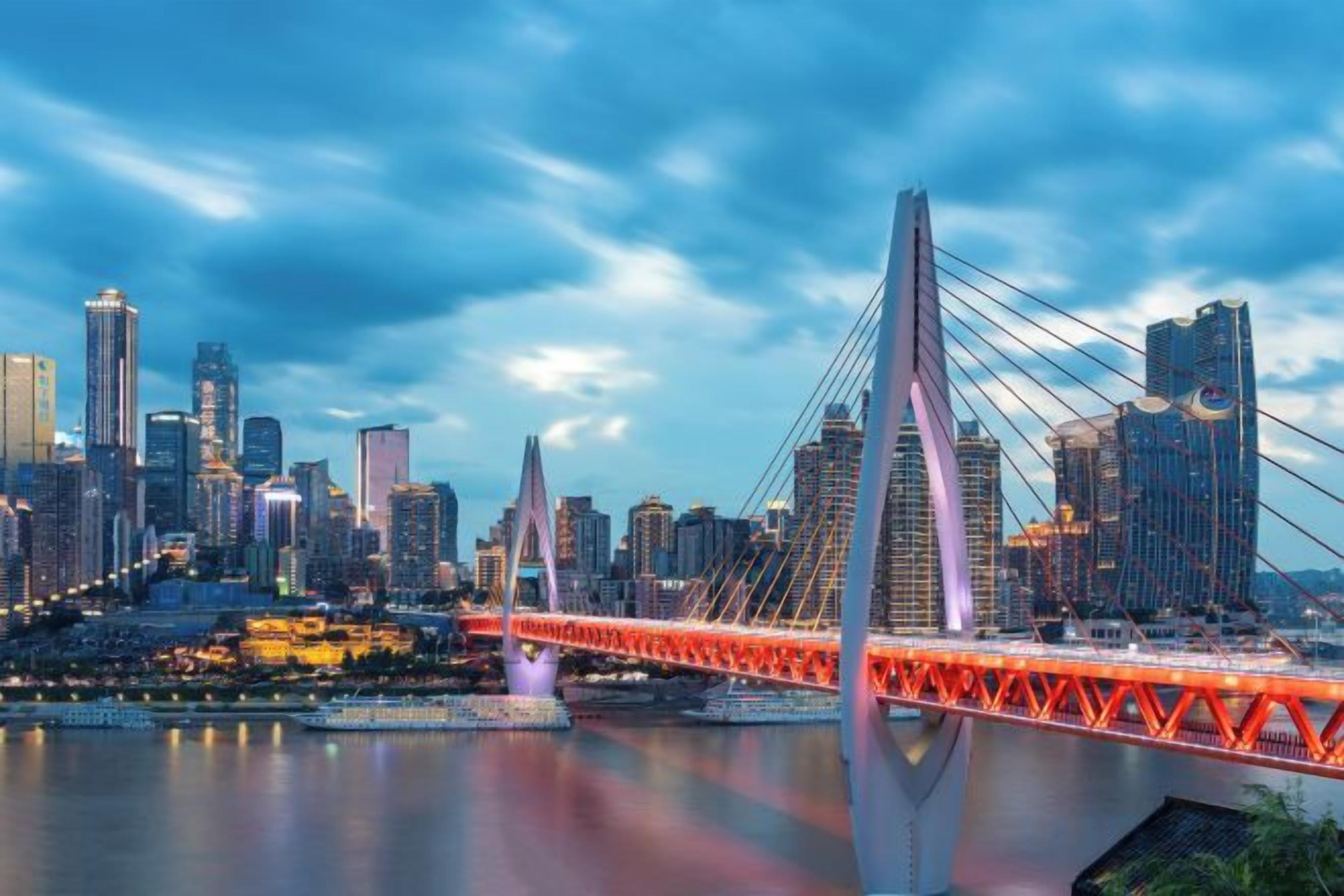 Un paisaje urbano con un puente rojo destacado y edificios modernos.