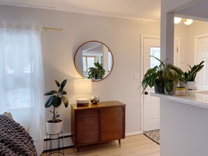 Relax in a serene space with a cozy throw blanket, a potted plant, and a stylish cabinet.