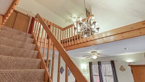 A staircase with wooden railings and carpeted steps leading to a second-floor landing. - Gray Manor (Hocking Hills Area) (Rockbridge)