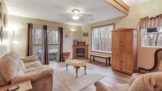 A cozy living room with a sofa, a wooden cabinet, and a fireplace. - Gray Manor (Hocking Hills Area) (Rockbridge)
