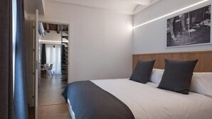 Ein modernes Hotelzimmer mit einem großen Bett, einem Holzkopfende und einem gerahmten Bild an der Wand.
