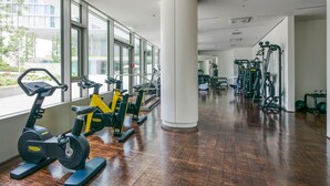 Une salle de sport équipée de vélos d’exercice, de tapis de course et d’appareils de musculation.