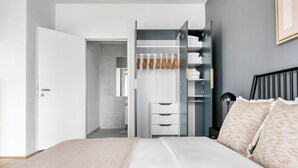 Une chambre Ă coucher moderne avec un lit, une armoire et une table de chevet.