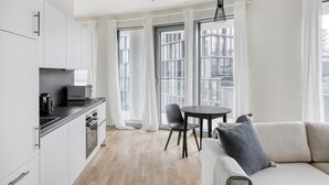 Un appartement moderne comprenant une cuisine, un coin repas et un salon.