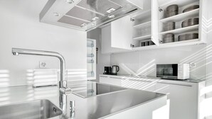 Una cucina moderna con lavello in acciaio inossidabile, bollitore e forno a microonde sul piano di lavoro.