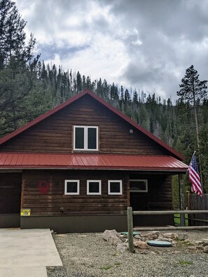 A wooden cabin with a red roof, a small porch, and an American flag. - Elegant Ten Mile Creek Cabin- Near Helena (Helena)