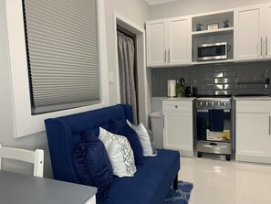 Cozy living space with a sofa, dining table, and kitchen area.