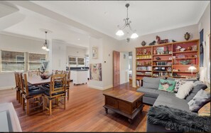 Relax in this inviting living area with a sofa, dining table, and bookshelf.