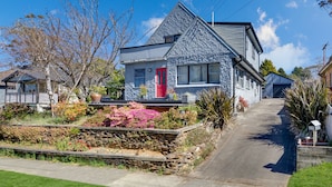 A two-story house with a red door, stone garden, and a clear blue sky. - Welcome to our charming, 2-level house just 5 min walk to 3 Sisters, Echo Point! (Katoomba)