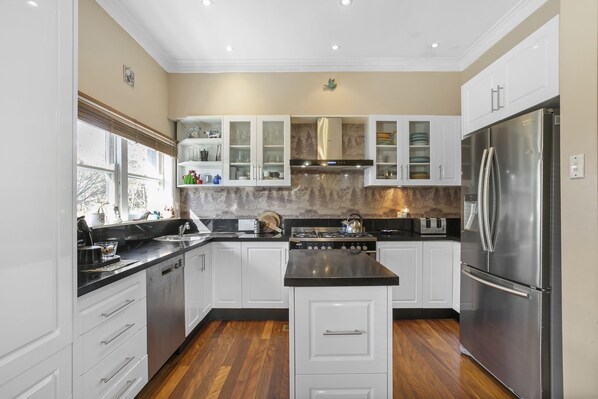 Enjoy cooking in this well-lit kitchen with a central island, oven, and range hood.