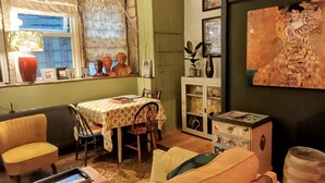 Un salon chaleureux avec une table à manger, des chaises, un canapé et une bibliothèque.