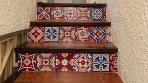 A staircase with colorful patterned tiles and a white door at the top. - Casa Gaudir - L'Estartit, Torre Vella (Estartit (L´))