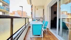 A balcony with a table and chairs, a sliding glass door, and a view of the cityscape. - 2190 LAS MURALLAS 1-1, VERY WELL LOCATED, CLOSE TO SHOPS AND THE BEACH, CIUDADELA DE ROSES AREA. (Roses)