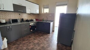 Una cocina con gabinetes grises, un microondas, un horno y un refrigerador.