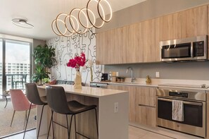 A modern kitchen with a central island, stainless steel appliances, and a minimalist design.