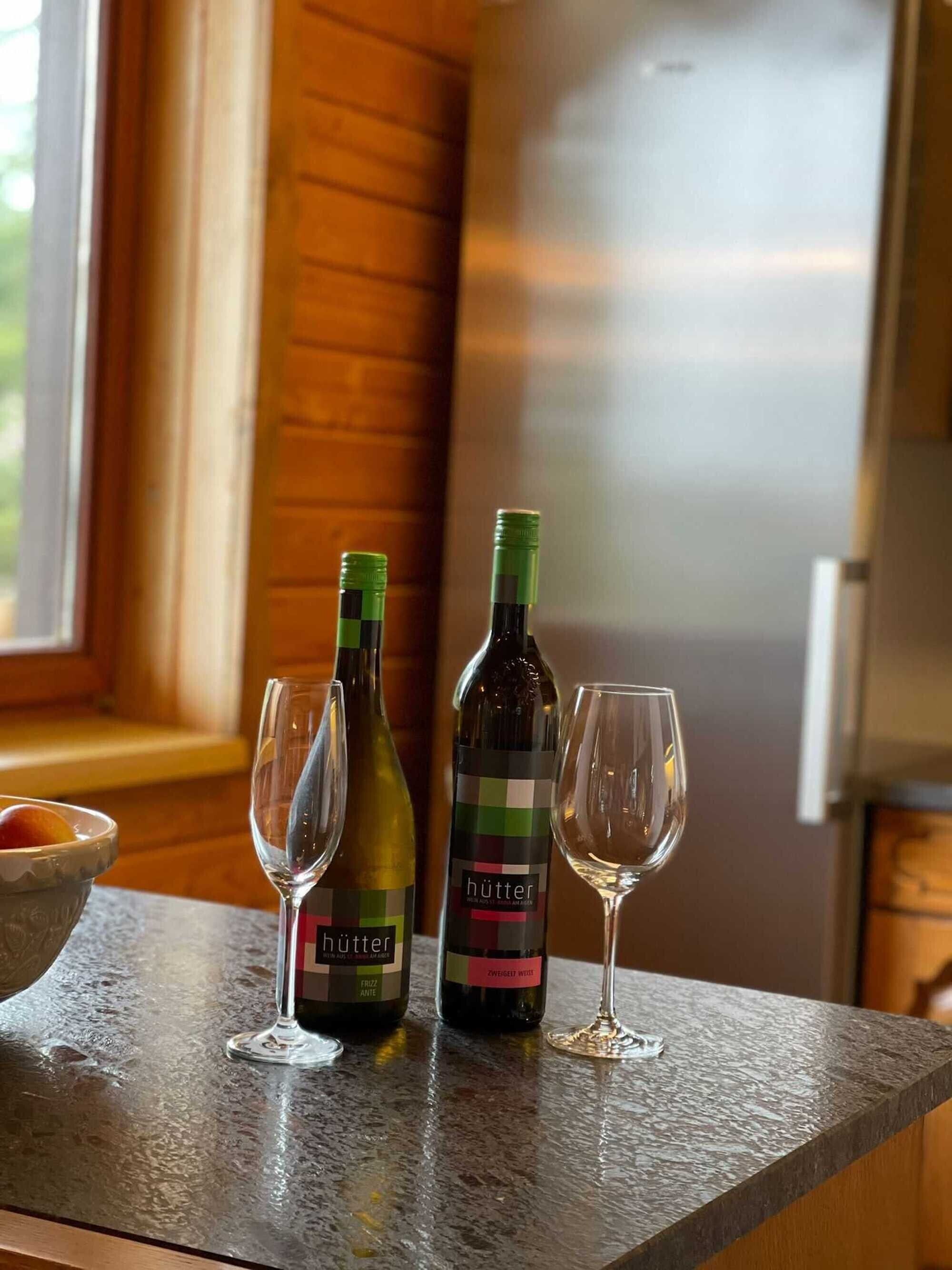 Un comptoir de cuisine avec deux bouteilles de vin et deux verres à vin.