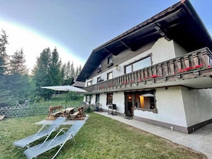 Un bâtiment à deux étages doté d’un balcon, d’un espace extérieur aménagé pour s’asseoir et d’une cour gazonnée.