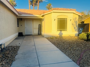 A house with a tiled roof, a welcome sign, a door, and a window. - Lovely, Peaceful, and Modern Las Vegas Home! Close to Strip! (North Las Vegas)