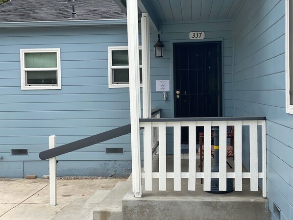 A blue house with a white porch and a black door. - WHOLE Family - Barrette - back - Hostel (Sacramento)