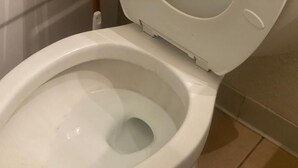 A white toilet with a closed lid in a bathroom.