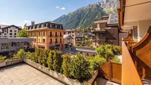 A residential area with modern buildings, a rooftop garden, and a mountain backdrop. - Duplex Aiguille du midi large terrasse, Chamonix, France (Chamonix)