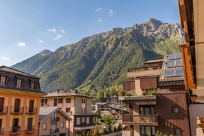Uma cidade montanhosa com edifícios, alguns com varandas, e uma montanha ao fundo.