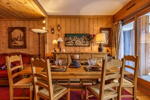 Ein Esszimmer aus Holz mit einem großen Tisch, gedeckt für sechs Personen, umgeben von Holzstühlen.