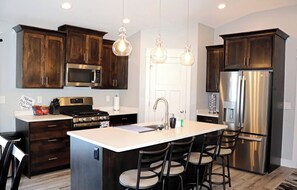 Enjoy cooking in this well-equipped kitchen with a central island, microwave, oven, and refrigerator.
