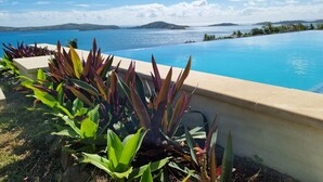 Una piscina con vista a un cuerpo de agua y tierra distante.