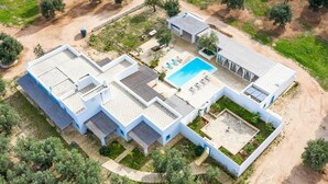 A modern villa with a swimming pool, multiple rooms, and a garden.