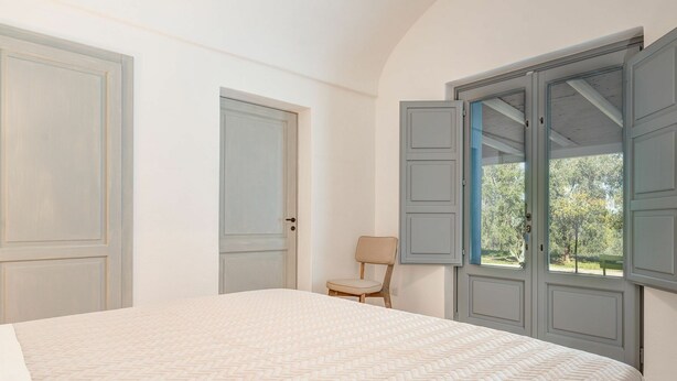 A bedroom with a bed, a chair, and a window with open shutters. - Villa in Savelletri Di Fasano with 5 bedrooms sleeps 10 (Savelletri Di Fasano)