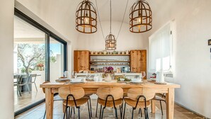 A modern kitchen with a wooden table and chairs, a built-in oven, and a large window. - Villa in Ostuni with 6 bedrooms sleeps 11 (Ostuni)