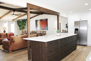 Enjoy cooking in this well-equipped kitchen with a central island and stainless steel appliances, perfect for dining and relaxing in the adjacent seating area.