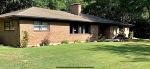 Charming single-story home with a front porch and well-manicured lawn.