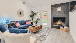 A modern living room with a sofa, coffee table, and fireplace. - Beautiful Fully Remodeled Home (Austin)