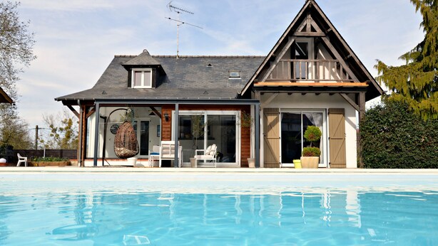 Et toetagers hus med en swimmingpool foran.