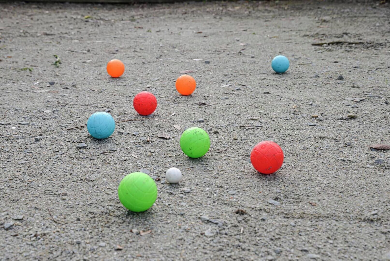 A collection of colorful balls scattered on a rough surface.