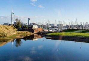 A calm water body reflecting buildings and a bridge, with a cityscape in the background. - Rampart View -  a house that sleeps 6 guests  in 3 bedrooms (Gosport)