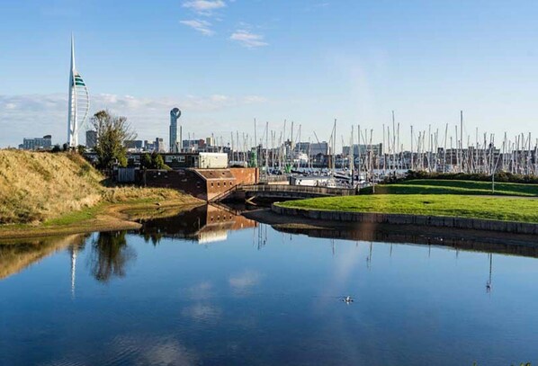 A calm water body reflecting buildings and a bridge, with a cityscape in the background. - Rampart View -  a house that sleeps 6 guests  in 3 bedrooms (Gosport)
