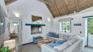 A spacious living room with a high ceiling, a built-in fireplace, and a large window.