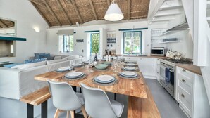 A modern kitchen with a wooden island, white cabinets, and a built-in oven.