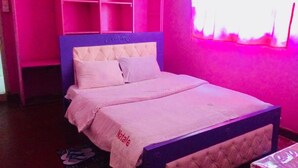 Ein Schlafzimmer mit einem Bett, einem Nachttisch und einem Fenster mit Vorhängen.