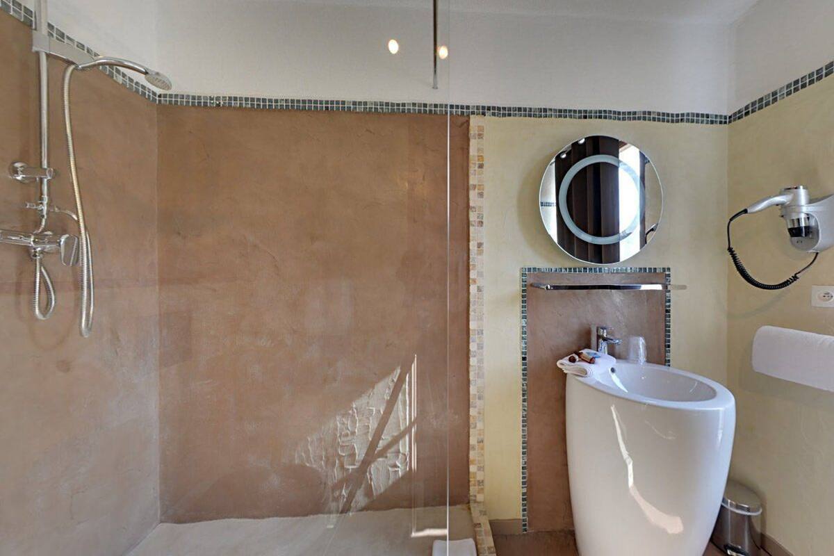 Une salle de bain avec une douche, un lavabo et un miroir.