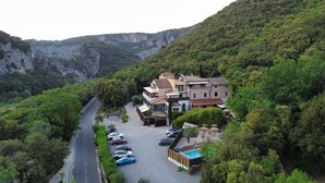 A hillside property with multiple buildings, a swimming pool, and a parking area. - Hotel Restaurant le Belvedere (Vallon-Pont-d'Arc)