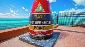 A monument labeled "Southernmost Point, Continental U.S.A." with "90 Miles to Cuba" and "Key West, FL" on it.