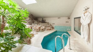 Un área de spa con piscina, una estatua y un perchero para batas.