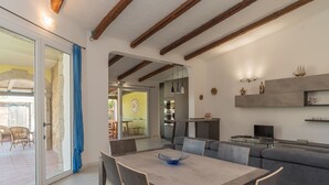Una cocina moderna con comedor, sofá y televisor.