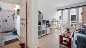 A modern living room with a sofa, coffee table, and a balcony with a view. - Apartment Caepionis close to the Beach with Shared Rooftop Terrace & Wi-Fi (Chipiona)