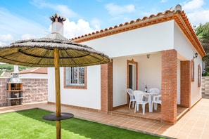A house with a patio, a grill, and a table with chairs. - Casa Torre de Meca 3 with Shared Pool, Terrace and Garden (Los Caños de Meca)