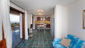Un espace de vie compact comprenant une kitchenette, un coin repas et un balcon avec vue.